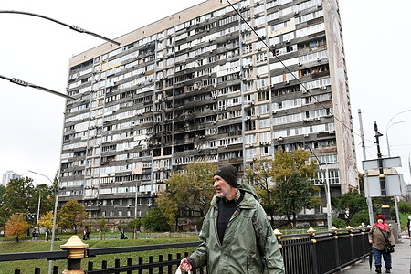 A man walks past a residential building damaged by a Russian drone strike. An apartment block in Kyiv caught fire after being struck by debris during a large-scale Russian drone and missile attack. The assault, part of a nationwide strike targeting Ukraine’s critical energy infrastructure, caused widespread power outages and water supply disruptions, particularly on the left bank of the Dnieper River. At least twelve people were injured in the capital as Ukraine’s air force reported that the barrage included ballistic, hypersonic, and other missile types, along with numerous drones.