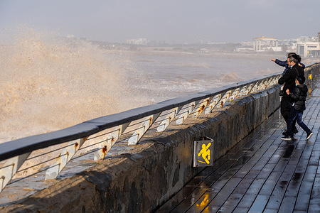 People enjoy a break from the rain on the boardwalk at the Old Port in Tel Aviv, Israel.