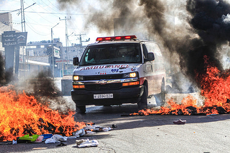 An ambulance passes through the flames while transporting an injured Palestinian as the Israeli armored military vehicles ran over them during a demonstration in support of Gaza, which has been under Israeli air strikes since October 7, near the Hawwara checkpoint, which is under Israeli control. Following its recent offensive inside Israeli territory, the Islamic resistance movement Hamas has called on all Palestinians in the West Bank to confront Israeli forces. Israel has bombarded Gaza following the Hamas attack which resulted in the death of over 1,000 Israelis. Israeli attacks have already resulted in over 1,500 deaths in Gaza, including hundreds of children. Thousands are reported to be wounded. Israel is poised to launch a ground offensive inside Gaza.