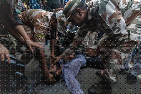 Police officers surround a demonstrator who fainted during detentions at an opposition protest. The demonstration, led by the Cockroach Janta Party (CJP) and supported by the INDIA bloc, demands the resignation of Chief Election Commissioner Gyanesh Kumar over alleged voter roll deletions and irregularities during recent electoral revisions, charges the Election Commission denies.