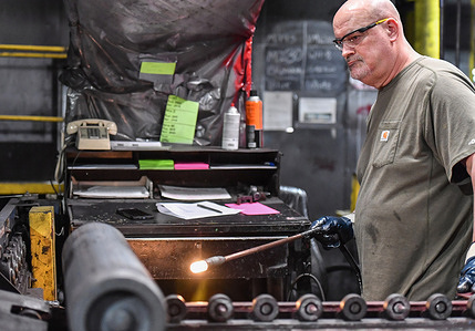 An employee inspects a cylinder that will become a shell. The Scranton Army Ammunition Plant held a media day to show what they make. The plant makes a 155mm artillery shell.