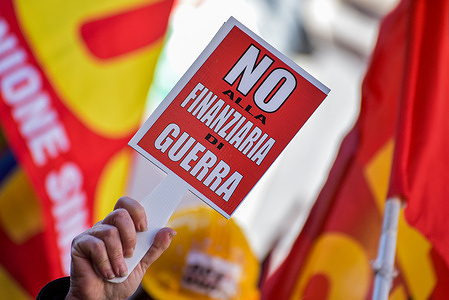 A protester holds up a placard expressing his opinion during the USB general strike demonstration against the government's budget at Piazza Montecitorio.