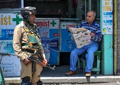 A Kashmiri man reads a newspaper as an Indian paramilitary trooper stands guard during restrictions imposed ahead of Indian PM Narendra Modi's visit in Srinagar, Indian administered Kashmir. 
Authorities today imposed restrictions in parts of the city in view of a strike and a march to the historic clock tower in city center Lal Chowk called by the separatists against Indian Prime Minister Narendra Modi's visit to Kashmir. Schools, shops and other businesses remained closed in the main city of Srinagar and other major towns of the Valley in protest at Modi's visit. Meanwhile there were reports of intermittent clashes between protesters and forces in some areas when people tried to march towards Lal Chowk.