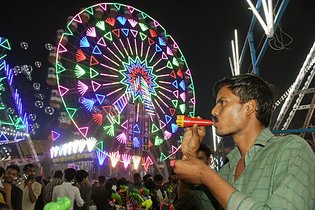 A seller blows bubbles to attract customers at Mahim (area in South Mumbai) fair in Mumbai. Annual fair is held every year to honour Pir Makhdoom Shah (Muslim spiritual saint) revered by Muslims and non-Muslims. The ten day event will be held from 27th December 2023 till 7th January 2024 offering variety of food and amusement rides.