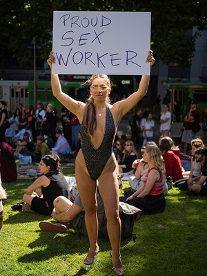 A woman holds a sign reading "Proud Sex Worker" during the vigil. A vigil and rally at the State Library of Victoria was attended by over 200 protesters, for the murder of Asian sex workers Hyun Sook Lisa Jeon and Yuqi Luo.