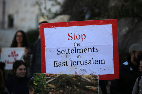 A placard that says "Stop Settlements in East Jerusalem" during the demonstration. Israeli left-wing peace activists and Palestinians participate in a demonstration against evictions from homes in the Israeli-annexed east Jerusalem neighborhood of Sheikh Jarrah. Israel's new firebrand National Security Minister Itamar Ben-Gvir, ordered the police commander on January 8 to authorize officers to remove Palestinian flags flying in public spaces.