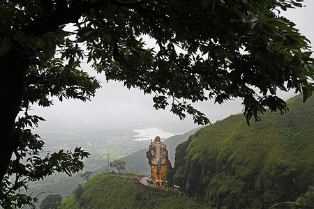 Idol of elephant-headed Hindu god Ganesha stands on the cliff of a hill at Matheran, a hill station in Raigad district on the outskirts of Mumbai. A majestic idol of elephant-headed Hindu god Ganesha is carved out of a single boulder which stands atop a cliff. It is known as 'Kadyavarcha Ganpati', (Ganesha on a cliff of a hill) in local language. It is very popular amongst tourists who visit Matheran hill station throughout the year which is known to be partial automobile free, eco-sensitive region with plenty of natural beauty surrounding it.
