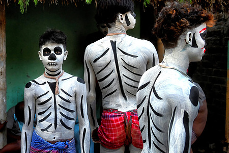 Hindu devotees pose for a photo with their painted bodies and faces during the annual Gajan Festival. Gajan is a Hindu festival celebrated mainly in rural West Bengal, lasting about a week and starting in mid-April. Participants, known as Sannyasis or devotees, express their devotion through acts of sacrifice and non-sexual pain. The festival emphasizes spiritual satisfaction through endurance and faith. It holds deep cultural and religious significance in the region.
