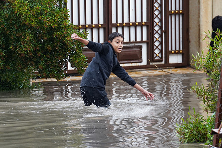 A boy walks through a flooded street in Mosul after heavy rains caused floods in the northern Iraqi city.