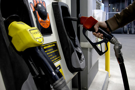 A woman refuels her car with regular gasoline at an ENEOS gas station in Shinjuku. Gasoline prices surge amid worsening tensions involving Iran. Some gas stations in Tokyo raised the price of regular gasoline by 26 yen per liter on the morning of March 12.