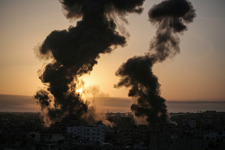 Explosions, fire and flames by Israeli air strikes over southern Gaza Strip in response to the barrage of rockets fired by the Palestinians into Israel.