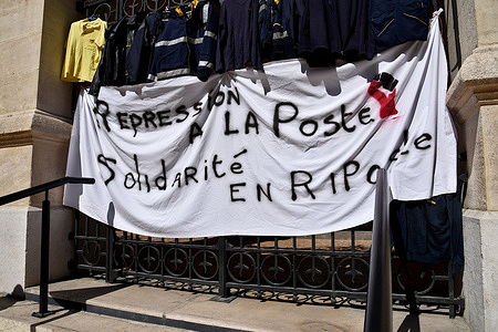 A banner and work jackets seen hanging at the gate during the protest. The Marseille postal workers held a strike against the reorganisation of rounds in the 1st, 2nd, 3rd, 4th and 14th arrondissements of Marseille which would lead to job cuts.