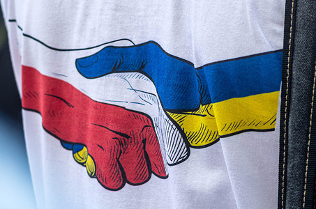 An illustrated image from a protester's t-shirt shows a hand coloured in the Polish flag shaking with a hand coloured in the Ukrainian flag during the demonstration. On the afternoon of Sunday the 19th of July, Ukrainians and pro-Ukrainian Poles gathered at the Ukrainian embassy in support of Ukrainian refugees who have recently been the subject of increased hateful rhetoric both in public and in political circles.