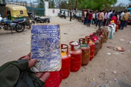 A man shows his domestic gas customer card while standing near long queues of empty LPG gas cylinders, waiting for the LPG cylinder distribution vehicle, which usually arrives every morning with fresh supplies. However, people say the distributors are not responding to their calls. People rushed to refill LPG cylinders after reports emerged that several hotels and restaurants might shut their kitchens due to a shortage of commercial gas cylinders. The LPG cylinder shortage in India (March 2026) is primarily driven by severe disruptions in imports from the Middle East, with 60% of the supply threatened by conflict-induced shipping delays at the Strait of Hormuz. Escalating tensions in West Asia have caused significant logistical bottlenecks and soaring maritime costs, resulting in delays in supplies.