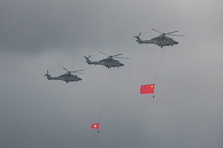 Helicopters carrying the flags of China and Hong Kong in the sky above Victoria Harbour. In commemoration of the 27th Anniversary of the establishment of the Hong Kong Special Administration Region, a variety of celebrations and events were held across the city.