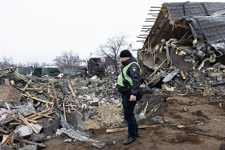 A police officer stands near a crater caused by a Russian missile attack on Kyiv. Russian forces launched ballistic missiles in Kyiv on December 11. All eight missiles were shot down by the Ukrainian forces and, four people were injured by these attacks.