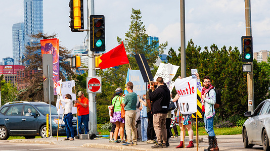 Members of the Communist Party of Canada (Marxist-Leninist) hold banners during a protest opposing Canada's allocation of funds to defense, NORAD, and NATO, instead of investing in social programs.