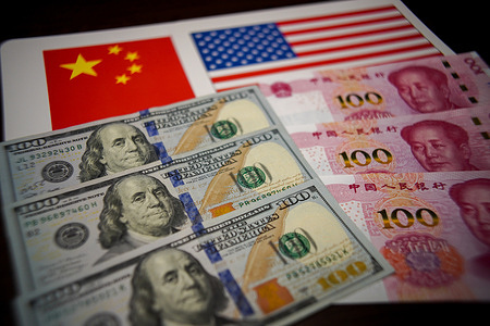 In this photo illustration, Three 100 US dollar bills and three 100 Chinese yuan banknotes are arranged over a background with the Chinese and American national flags.