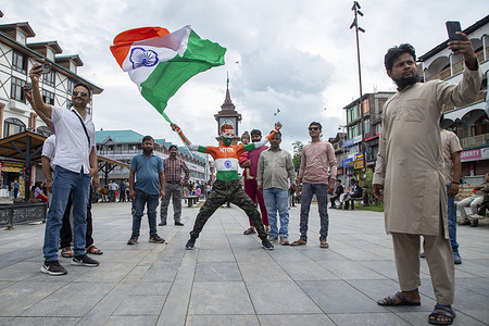 People take photos with an Indian man painted with Indian national flag as he shout pro India slogans, during India's 79th Independence day celebrations in Srinagar. India gained independence from British rule on August 15, 1947.