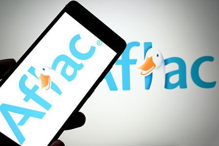 In this photo illustration, an Afiac logo is seen displayed on a smartphone and in the background.