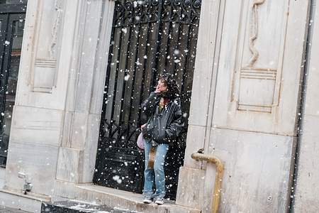 A woman is seen smoking a cigarette in the snow. On the first day of the new year, heavy snowfall blanketed Istanbul around noon. People enjoyed pleasant moments on Istiklal Avenue.