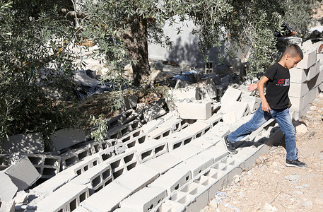 A Palestinian child climbs over the wall of his family's destroyed home following a vandalistic attack by Jewish settlers in the village of Beit Marin, north of Nablus in the West Bank. The settlers attacked Palestinian homes, destroying walls and infrastructure, cutting off electricity, and stealing homes' contents.