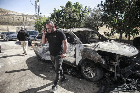 Palestinians inspect a burned car in the village of Burqa. Palestinians reported that Jewish settlers set fire to a Palestinian car. Jewish settlers launched attacks on Palestinian villages burning vehicles and property after an Israeli woman was killed by Palestinian gunmen near the Salfit area.