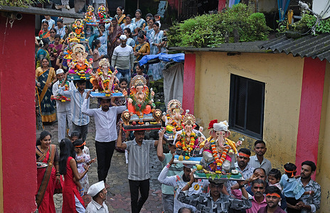 Devotees walking in a line carry idols of elephant-headed Hindu god Ganesha on their head for immersion at a village in Raigad district on the outskirts of Mumbai. The ten day Ganesh Chaturthi festival will end on Anant Chaturdashi (6th September 2025) where devotees will immerse all big and small idols in a free flowing water body signifying the birth cycle of Lord Ganesha.