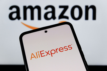 In this photo illustration, an AliExpress logo seen displayed on a smartphone and the Amazon logo in the background.