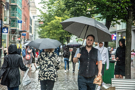 A man walks along Market Street while holding an umbrella during a rainy day.
Greater Manchester was bombarded by rain and thunderstorms today after a two week long heat wave.
