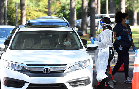 A health worker prepares to perform a nasal swab sample at a COVID-19 rapid testing site at Barnett Park.
With just three days until Thanksgiving, and increasing numbers of coronavirus cases in Florida, record numbers of residents are visiting testing locations as they prepare to gather with family members to celebrate the holiday.
