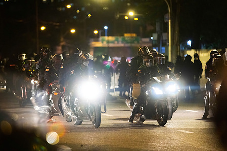 Riot police on their motorbikes are chasing the protesters during the demonstration.Protesters clashed with riot polices at Din Daeng Junction in Bangkok to demand resignation of Prayuth Chan-O-Cha, prime minister of Thailand.