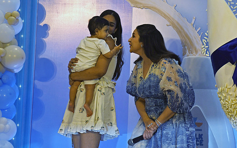 Bollywood actress Parineeti Chopra (R) interacts with a baby during the unveiling of Johnson's Baby new nourishment range in Mumbai.