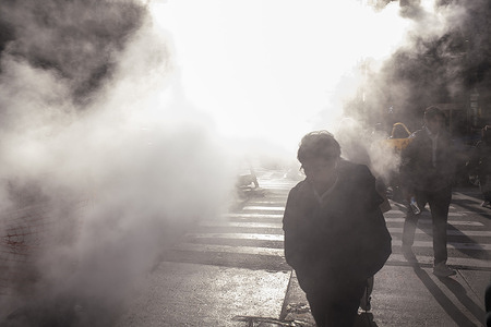 People cross Lexington Avenue as steam vents from a pipe connected to underground repair work in the Manhattan borough on March 13, 2025 in New York City. Steam is used for heating and cooling systems in thousands of buildings across New York City.