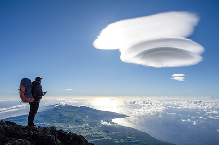 A hiker is seen exploring the Pico mountain, in the Azores. Pico Island is the second largest island in the Azores Archipelago, in the North Atlantic and is where the highest mountain in Portugal is located, with 2,351 m of altitude. The immense volcanic cone of Pico Mountain, the third largest volcano in the Atlantic, dominates the island's landscape.