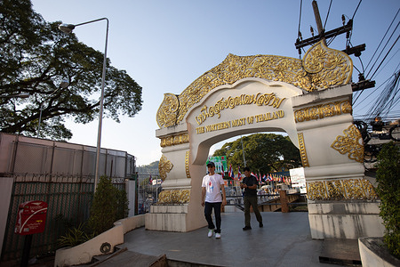Local Thai tourists walk through "The Northern Most of Thailand" Gate in Mae Sai with the border bridge in the background connecting Thailand to Myanmar now open for local Burmese tourists to come and visit Mae Sai for 1-day trip.