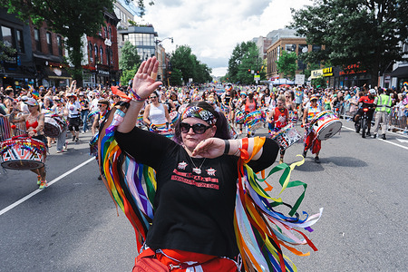 Protestors march while playing drums during the World Pride parade.