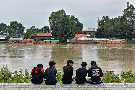 People watch the river Jehlum flowing over the flood-alert mark following incessant rains in Kashmir valley. At least 36 people lost their lives after heavy rains triggered fierce floods and landslides in Jammu and Kashmir. Heavy rainfall flooded several residential and commercial areas.