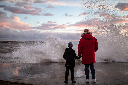 People seen watching the waves rising on the Kadikoy beach due to the southwest wind in Istanbul.