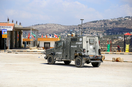 An Israeli military vehicle seen near flags of countries participating in the FIFA World Cup, in the city of Nablus in the northern occupied West Bank.