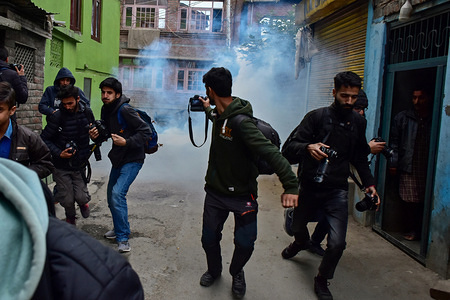 Photojournalists run for cover as tear gas canister fired by the government forces explode near the shrine in Srinagar, Kashmir. 
Government forces in old city of Srinagar disallowed special prayers being held annually on the festival of the Sufi Saint - Khawawja Naqshbandh Sahab.