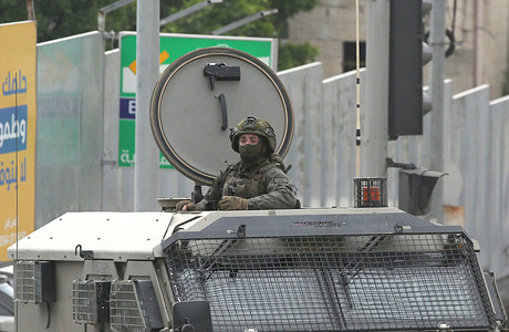An Israeli soldier seen standing alert inside a military vehicle in the central market during a military operation. Israeli forces raided the market in the city center and opened fire on shoppers who were throwing stones at the soldiers, killing a 26-year-old Palestinian man and wounding 12 others who were taken to hospitals in Nablus, according to medical sources.
