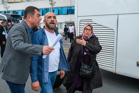 A woman and a man are directed by a bus attendant to the bus they will be boarding. Deploying a total of 815 buses, The ruling Justice and Development Party (also known as the AK Party) has reportedly provided free transportation for voters in different cities. The Justice and Development Party is led by Recep Tayyip Erdoğan, Turkey's current president who is standing for re-election.