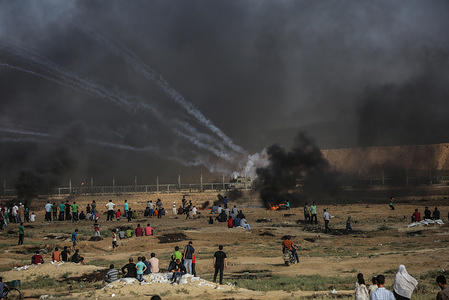 Palestinian seen burning tires while the Israeli forces fire tear gas during the clashes.
Palestinian protesters clash with Israeli forces in northern Gaza Strip.
