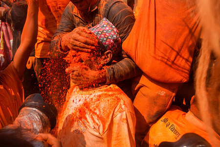 A devotee smears his friend's face with vermilion powder during the Sindur Jatra, a traditional festival marking the arrival of spring and the Nepali New Year as part of Bisket Jatra celebrations.