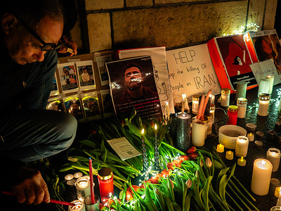 An Iranian man lights a candle in honor of the victims as attendees gather at Domplein in Utrecht for a candlelight vigil in support of individuals opposing Iran’s Islamic regime. Protests originating in Iran have sparked solidarity demonstrations across Europe. A US-based human rights organization says more than 2,500 people have been killed in the protests, most of them demonstrators.