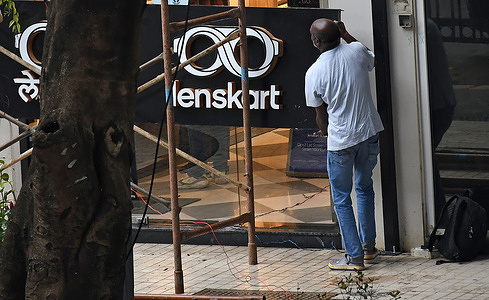 A man holds a signage of Lenskart after fixing it outside their store. Lenskart is an Indian multinational eyewear brand company started by former Microsoft employee Peyush Bansal along with Amit Chaudhary, Neha Bansal (wife of Peyush Bansal) and Sumeet Kapahi. It has more than 2000 stores across the country selling eyewear and also online through their website and mobile app.