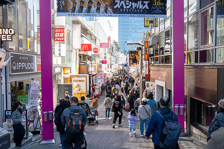 Pedestrians walk along the busy shopping street of Takeshita Street in the Harajuku district of Tokyo, Japan. Takeshita Street in Harajuku, Tokyo is a narrow, pedestrian shopping street known for its colorful youth fashion, quirky boutiques, and street food stalls. It’s a cultural hub for Japan’s teen fashion scene, drawing crowds with its vibrant energy and constantly evolving trends.