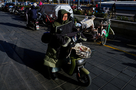 A woman seen riding a bicycle while carrying a child as they travel along the road