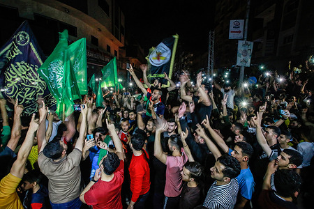 Palestinians celebrate on the street following a ceasefire brokered by Egypt between Israel and the ruling Islamist movement Hamas in Gaza City.
A ceasefire between Israel and Hamas, the Islamist movement which controls the Gaza strip, came into force early on may 21, 2021 after 11 days of deadly fighting that pounded the Palestinian enclave and forced countless Israelis to seek shelter from rockets.